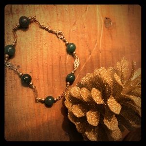 Cabochan (dark) jade and gold bracelet.